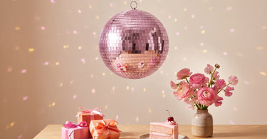Pink discokugle fra Rice over et bord med fødselsdagsgaver og kage