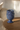 Blå vase i stentøj fra Kersten, styled på varmt egetræsbord ved sofa